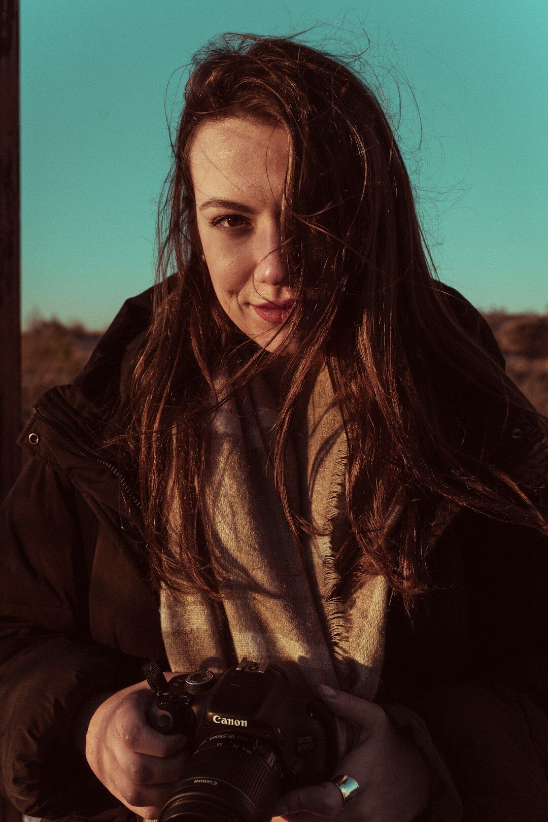 Studio portrait of a Danish woman in her thirties with a camera around her neck