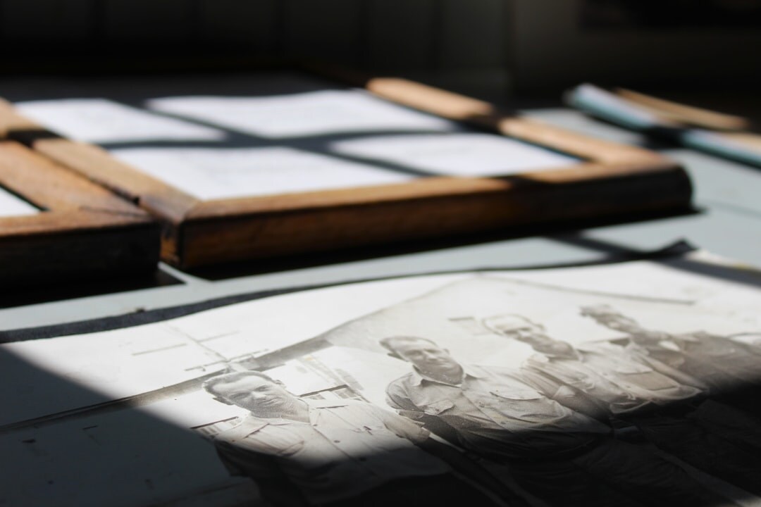 A small editorial team reviewing printed photographs on a table